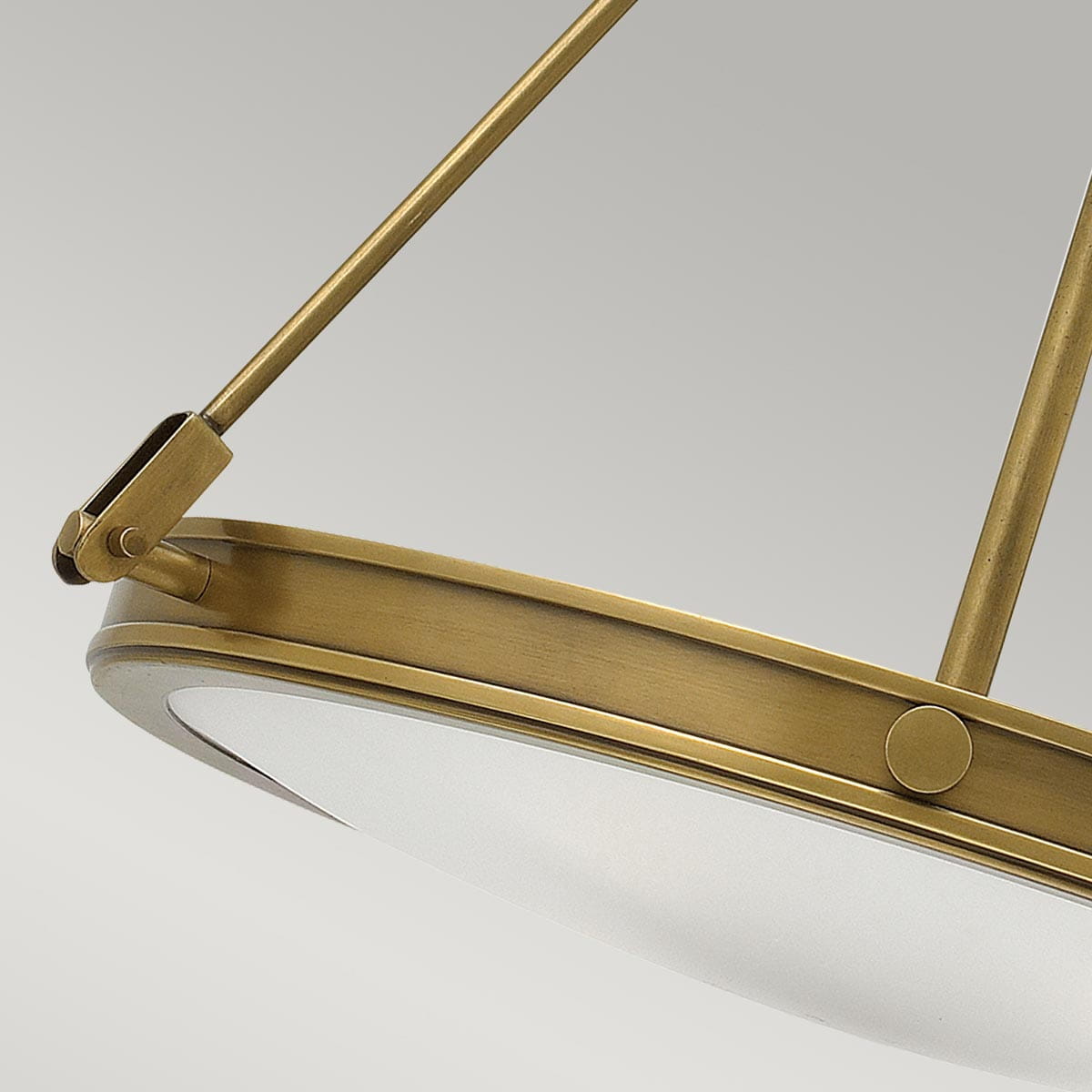 Lampa wisząca Aurea w kolorze stary mosiądz, z okrągłym, matowym kloszem. Ujęcie z boku, pokazujące mocowanie oraz elementy konstrukcyjne. Produkt wiszący, idealny do nowoczesnych wnętrz. Tło w jasnym, jednolitym kolorze.