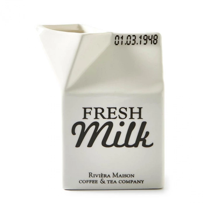 Pojemnik na mleko Carton Riviera Maison w kolorze białym, o kształcie zbliżonym do kartonu, z widocznym napisem FRESH Milk w czarnym kolorze. Produkt stoi w pozycji frontalnej, prezentując detalicznie krawędź oraz lekko zaokrąglony dzióbek.