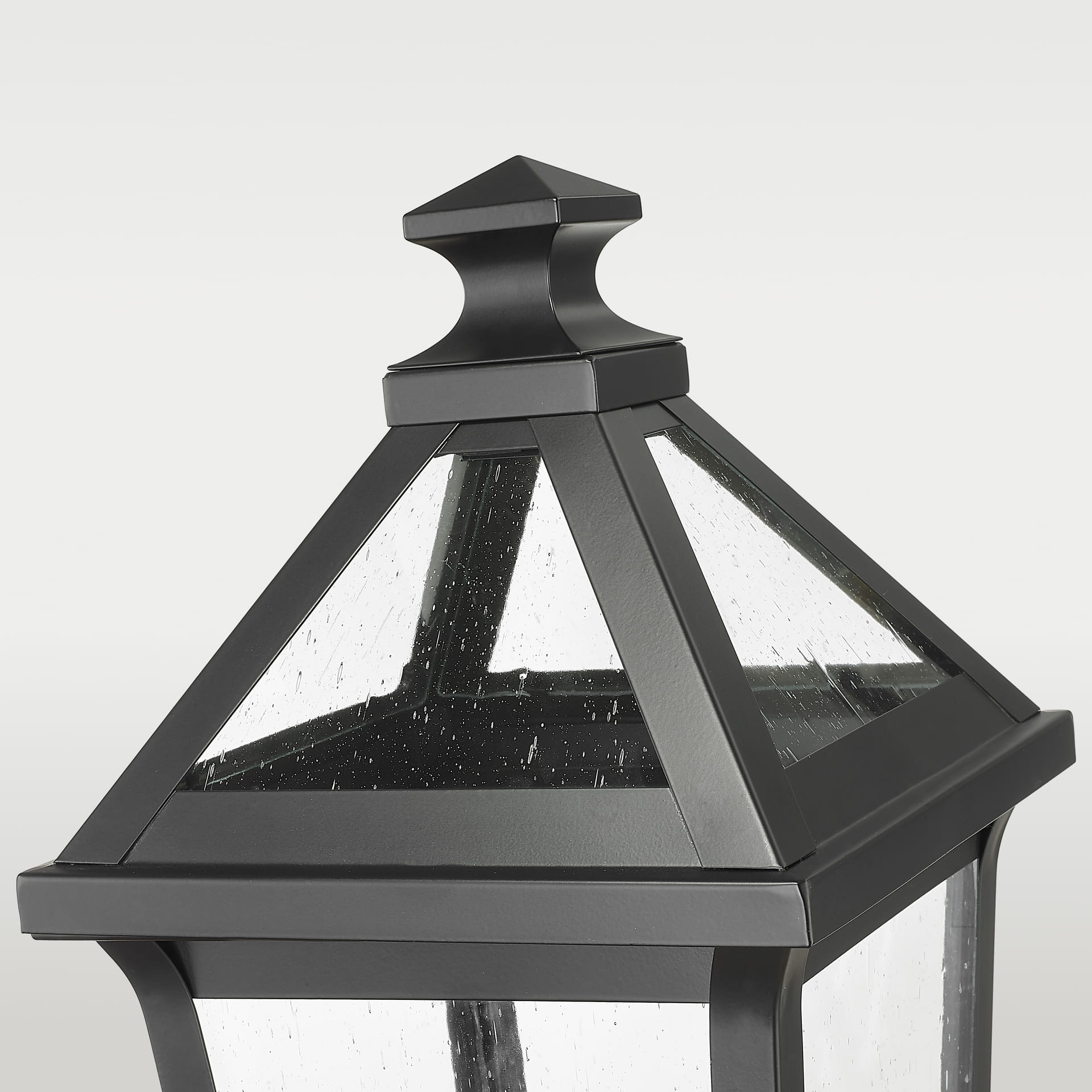 Lampa ogrodowa stojąca Fiorente o wysokości 60 cm, w kolorze czarnym, wykonana z metalu. Produkt z widocznym, stożkowatym daszkiem i szklanymi ściankami, w których znajdują się drobne krople, tworzy elegancki akcent w aranżacji ogrodowej.